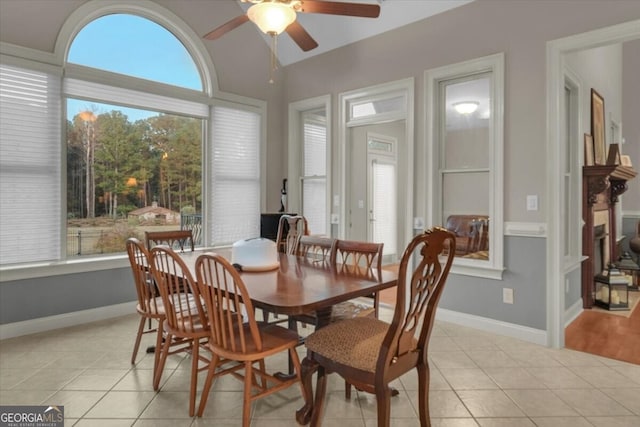 dining space with light tile patterned floors and ceiling fan