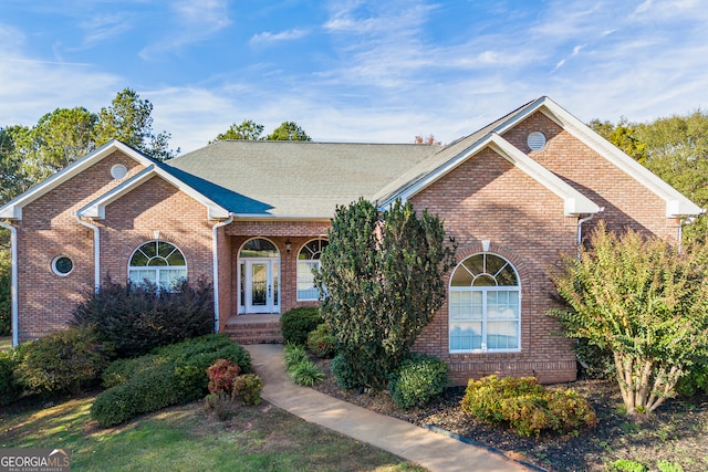 view of front of property featuring a shingled roof and brick siding