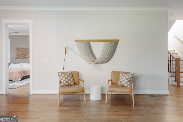 living area with hardwood / wood-style floors and crown molding