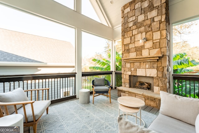 sunroom / solarium with a fireplace, a wealth of natural light, and vaulted ceiling