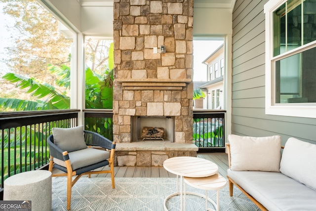 sunroom featuring an outdoor stone fireplace