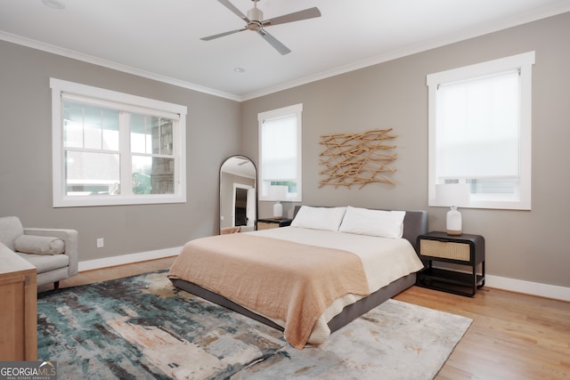 bedroom featuring ceiling fan, ornamental molding, and light hardwood / wood-style flooring