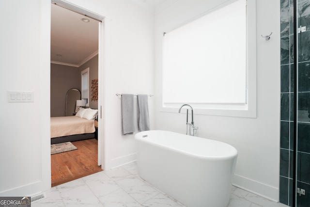 bathroom featuring hardwood / wood-style flooring, a tub to relax in, and crown molding