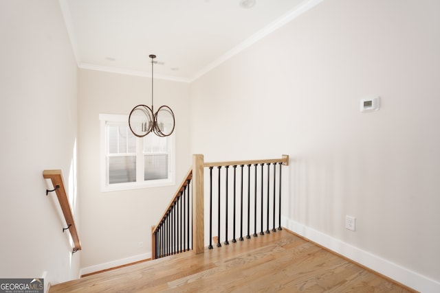 stairway with a notable chandelier, wood-type flooring, and crown molding