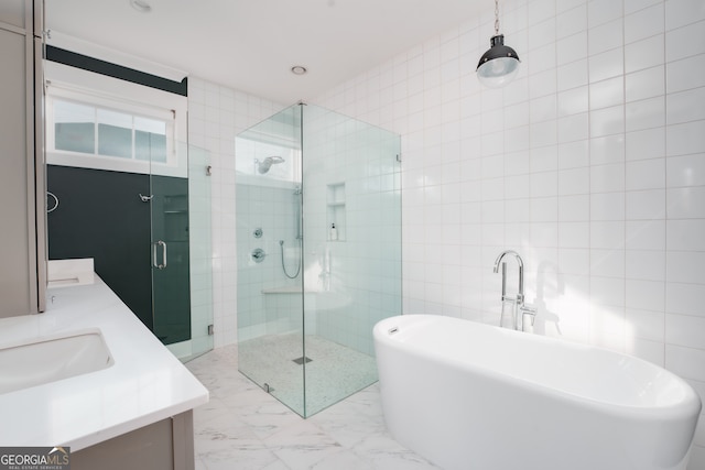 bathroom with shower with separate bathtub, vanity, and tile walls