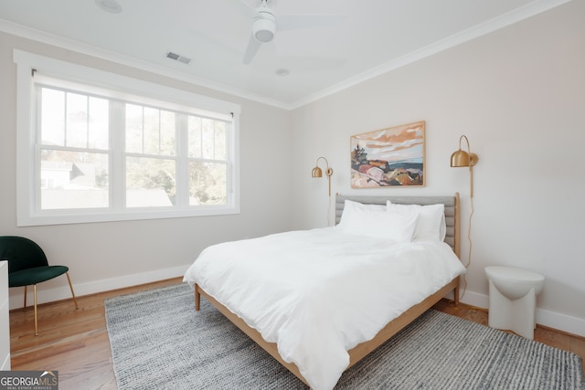 bedroom with light wood-type flooring, ceiling fan, and ornamental molding