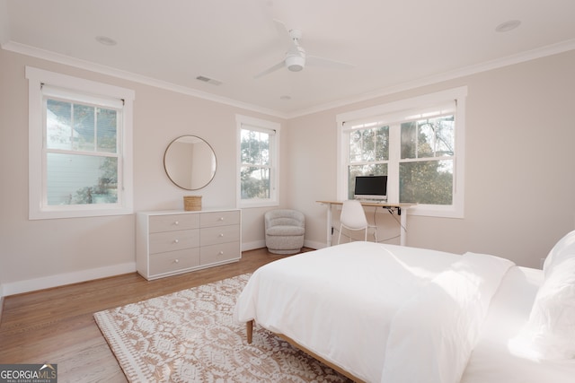 bedroom featuring multiple windows, ceiling fan, light hardwood / wood-style floors, and ornamental molding