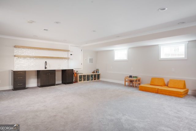 living area featuring light carpet, a healthy amount of sunlight, and ornamental molding