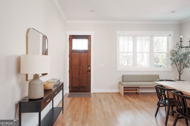 foyer with light wood-type flooring and crown molding