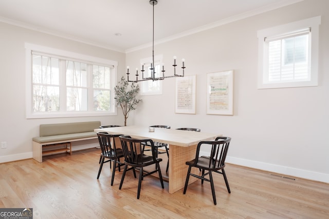 dining room featuring crown molding, light hardwood / wood-style flooring, and a chandelier