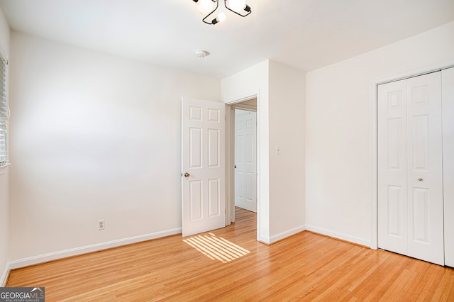 unfurnished bedroom with a closet and light hardwood / wood-style flooring