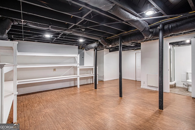 basement with wood-type flooring and electric panel