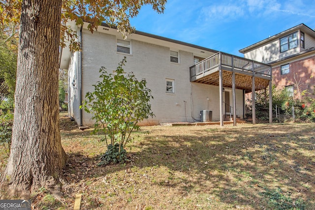 rear view of property with a lawn and a wooden deck