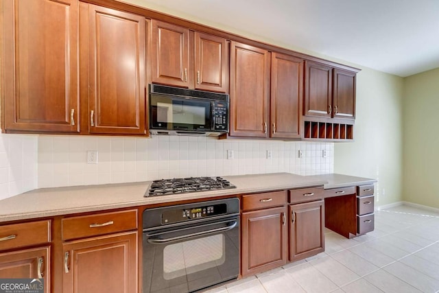 kitchen featuring tasteful backsplash, light tile patterned floors, and black appliances