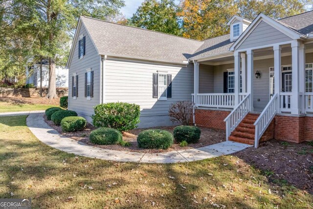 view of front of house featuring covered porch and a front lawn