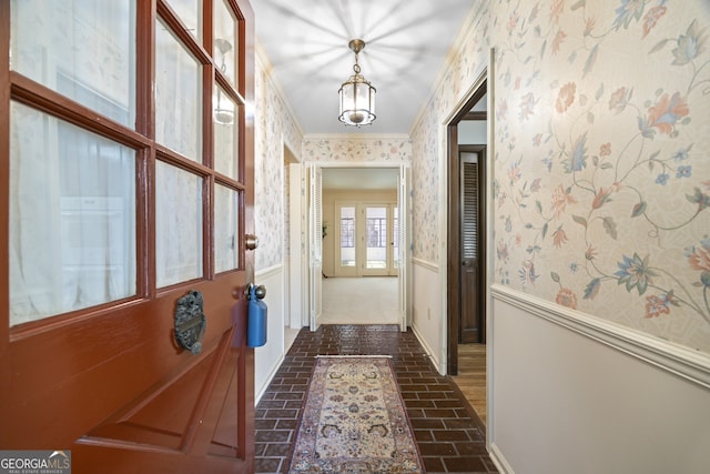 corridor featuring a chandelier and ornamental molding