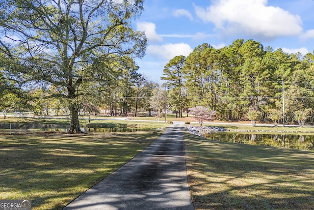 surrounding community featuring a lawn and a water view