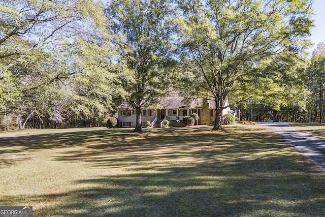 obstructed view of property featuring a front lawn