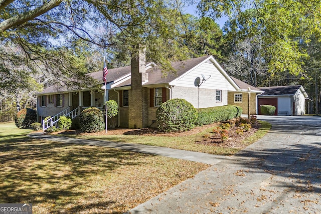 ranch-style home featuring a garage, an outbuilding, and a front lawn