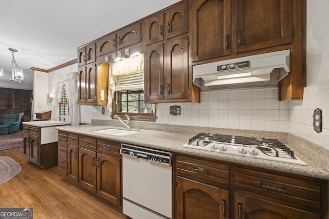 kitchen featuring sink, pendant lighting, light hardwood / wood-style floors, white appliances, and ornamental molding