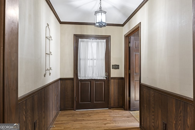 doorway to outside featuring crown molding and light hardwood / wood-style flooring