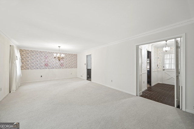 unfurnished room featuring a notable chandelier, carpet floors, and ornamental molding