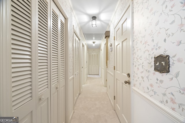 hallway with light colored carpet and ornamental molding