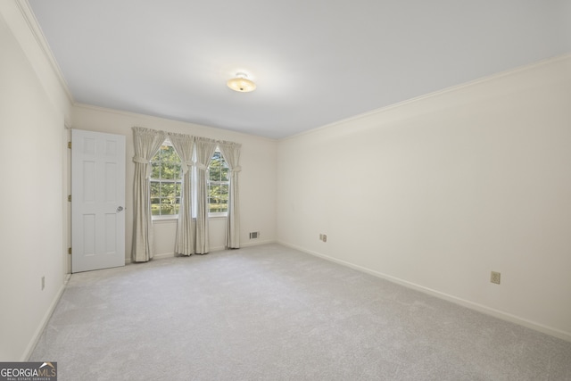 carpeted empty room featuring crown molding