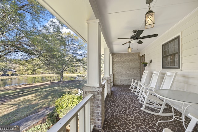 exterior space featuring a porch, a water view, and ceiling fan