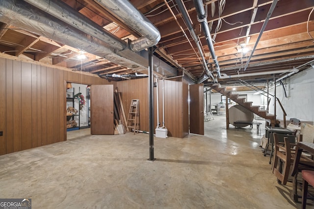 basement featuring wood walls