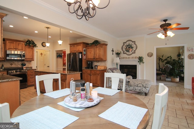 dining space featuring ceiling fan with notable chandelier and crown molding