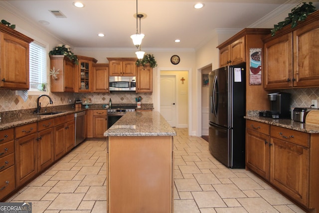 kitchen with sink, tasteful backsplash, decorative light fixtures, a kitchen island, and appliances with stainless steel finishes