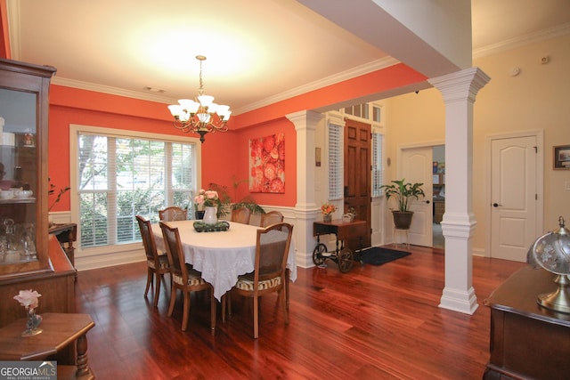 dining space featuring a chandelier, dark hardwood / wood-style flooring, ornate columns, and ornamental molding