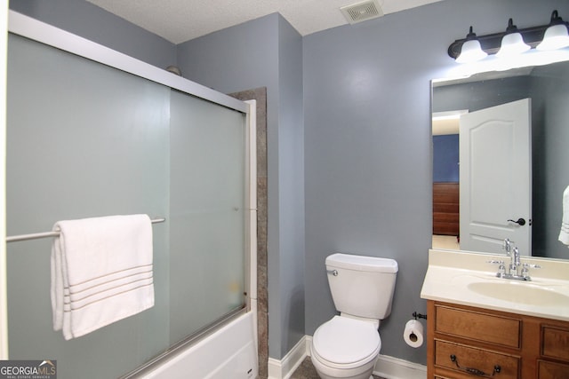 full bathroom featuring vanity, a textured ceiling, toilet, and bath / shower combo with glass door