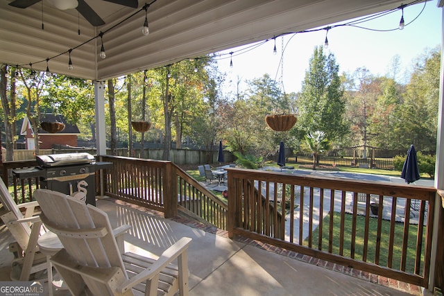 wooden deck featuring area for grilling and ceiling fan