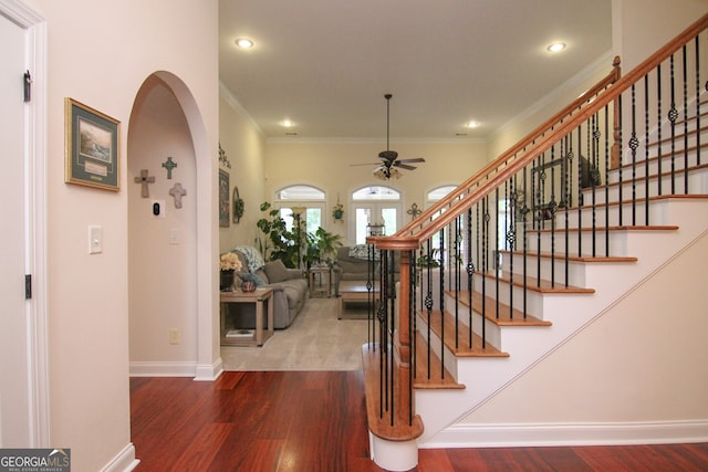 stairway featuring hardwood / wood-style flooring, ceiling fan, and ornamental molding