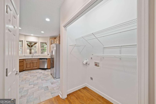 laundry room featuring washer hookup and light hardwood / wood-style floors