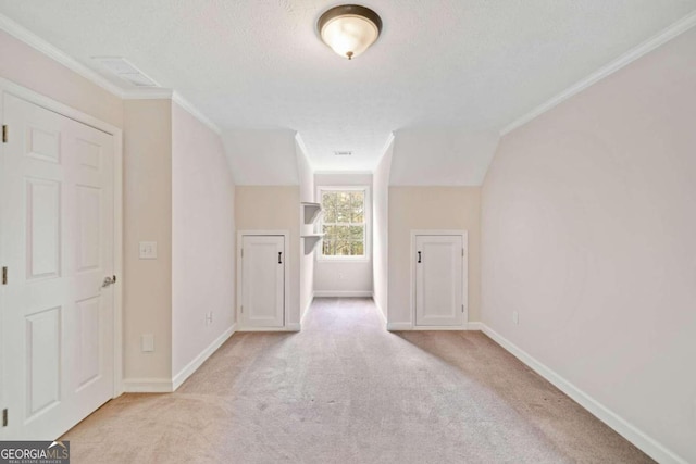 corridor featuring light carpet, lofted ceiling, a textured ceiling, and ornamental molding