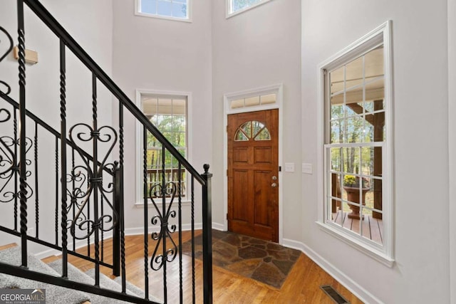 entrance foyer featuring hardwood / wood-style floors and a towering ceiling