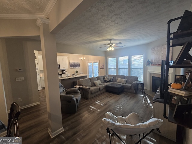 living room featuring ceiling fan, sink, dark wood-type flooring, crown molding, and a textured ceiling