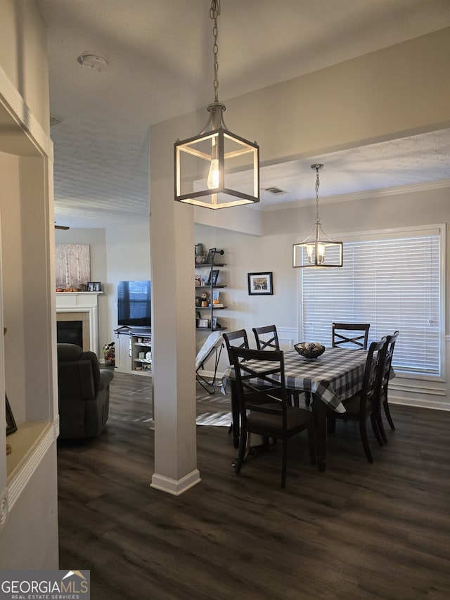 dining space featuring a chandelier, a textured ceiling, and dark hardwood / wood-style flooring