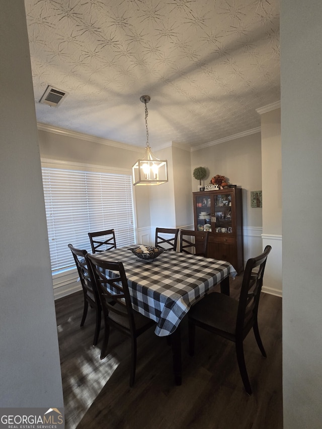 dining area with dark hardwood / wood-style flooring, ornamental molding, and a chandelier