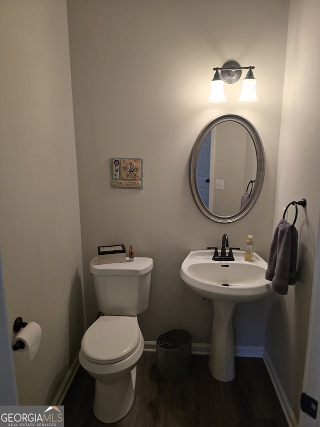 bathroom featuring hardwood / wood-style flooring and toilet