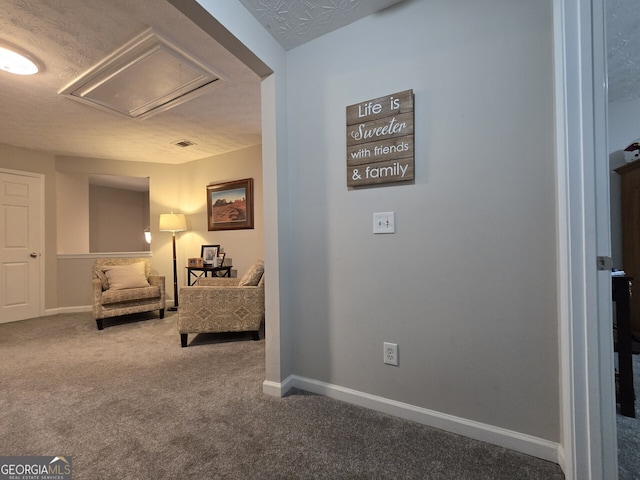 sitting room featuring carpet flooring and a textured ceiling