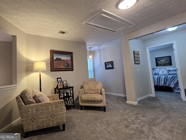 sitting room with a textured ceiling and dark carpet