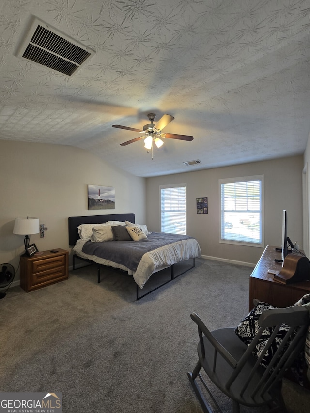 carpeted bedroom with ceiling fan and a textured ceiling