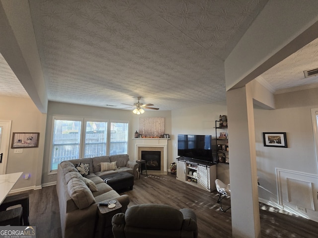 living room with a textured ceiling, dark hardwood / wood-style flooring, and ceiling fan