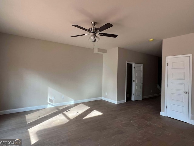 spare room with dark hardwood / wood-style flooring and ceiling fan