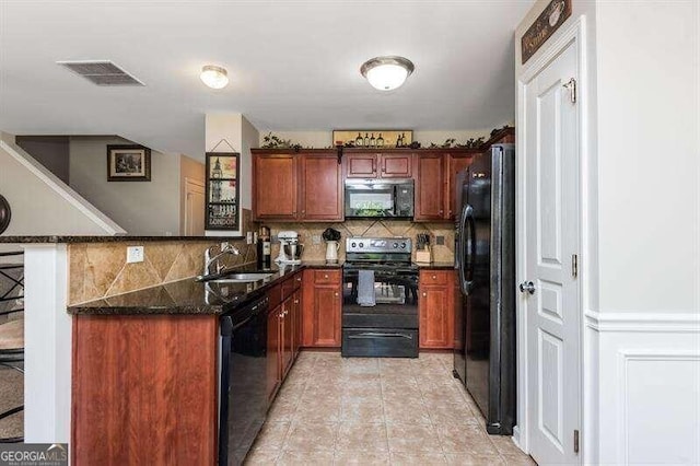 kitchen featuring kitchen peninsula, backsplash, dark stone counters, sink, and black appliances