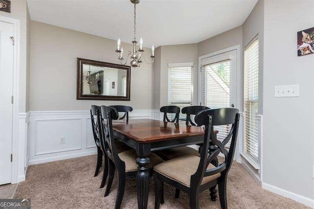 carpeted dining room featuring a chandelier